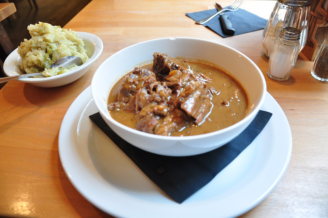 A plate of Flemish beef stew cooked in beer, served with potatoes