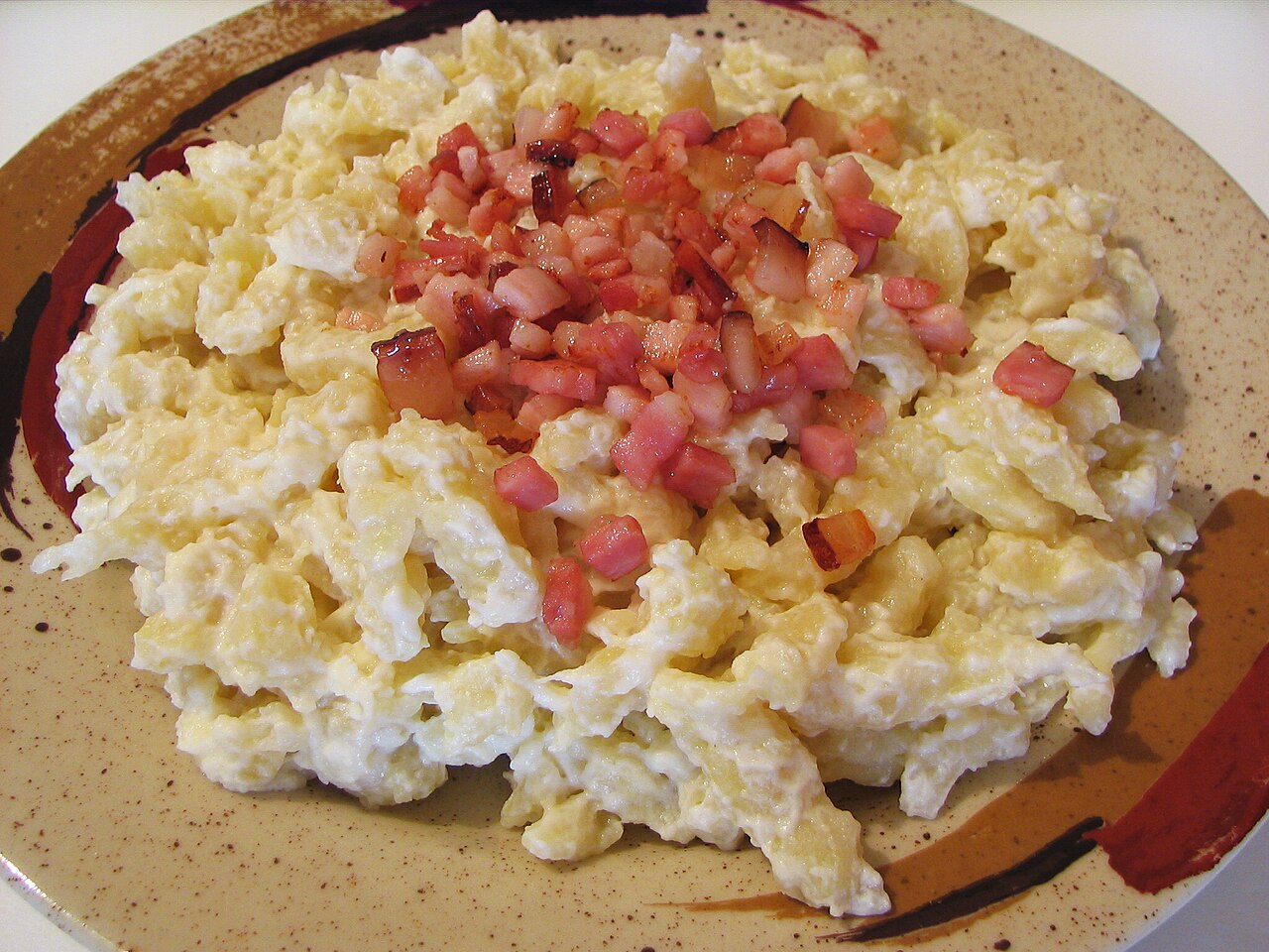 A plate of bryndzové halušky, small potato dumplings in sheep's cheese sauce topped with bacon