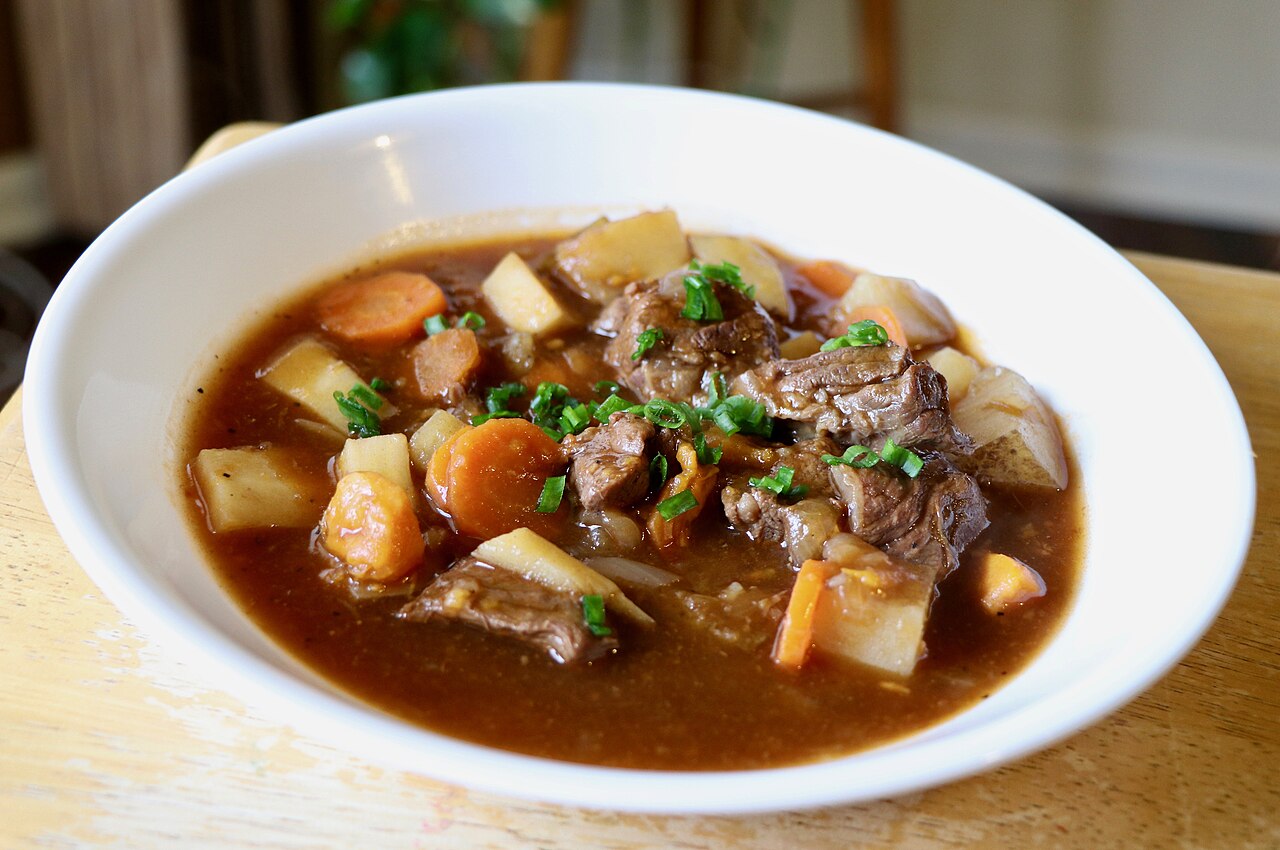 A bowl of Irish stew with chunks of meat, carrots and potato in a thick broth