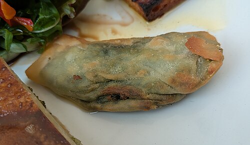 A barbajuan, the fried Monegasque pastry, served on a plate as part of a Monegasque assortment