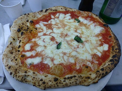 A Neapolitan pizza margherita with tomato, mozzarella and basil on a plate