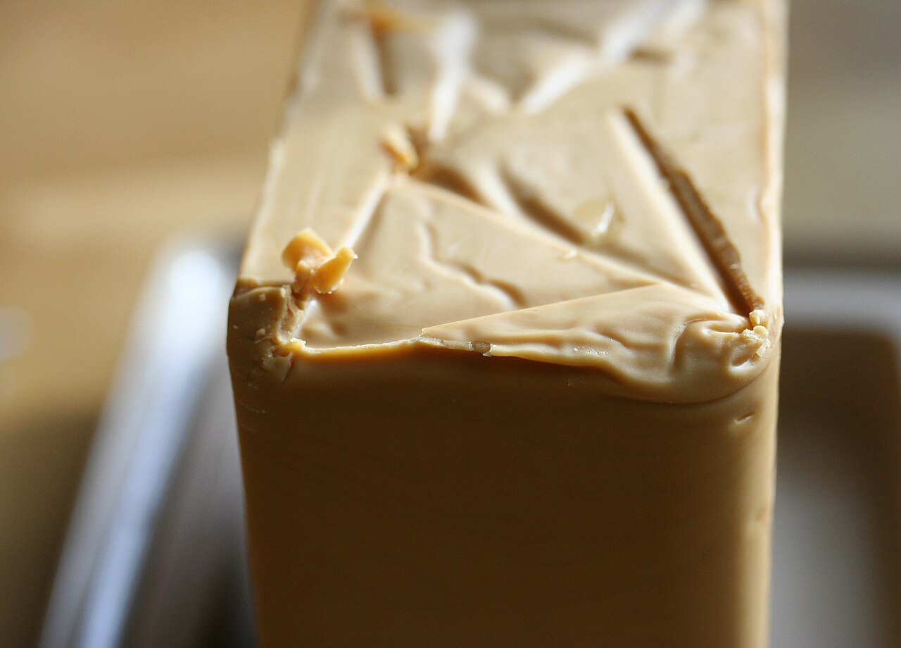 A close-up of brunost, the brown Norwegian cheese, cut into slices