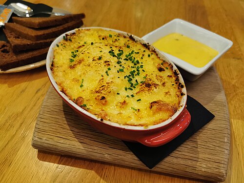Plokkfiskur, a baked dish of fish and potato under melted cheese, served with dark rye bread