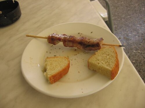 Souvlaki skewers served with pitta, tomato and onion on a plate
