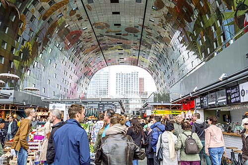 The interior of the Markthal in Rotterdam with food stalls below the arched ceiling