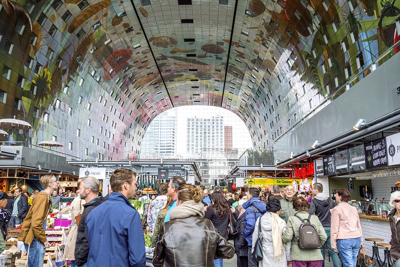 The interior of the Markthal in Rotterdam with food stalls below the arched ceiling