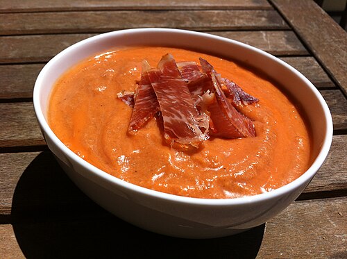 A bowl of salmorejo, a cold cream of tomato and bread, topped with jamón