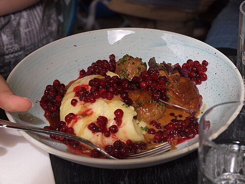 A plate of Swedish meatballs with sauce and lingonberries at a restaurant in Gamla stan, Stockholm