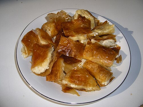Slices of bougatsa custard pie dusted with icing sugar on a plate