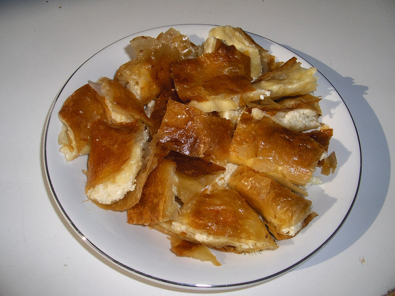 Slices of bougatsa custard pie dusted with icing sugar on a plate
