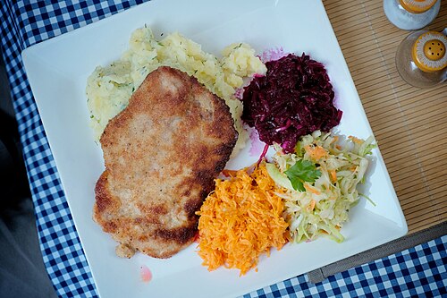 A breaded pork cutlet, kotlet schabowy, served on a plate